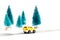 Small yellow car on paper road against fir-trees on white background. Traffic on country road.