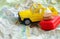 Small yellow car,suitcase and euro coins on a map