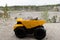 Small yellow car toy, mining truck with stones.