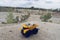 Small yellow car toy, mining truck with stones at the hill at the background of quarry,