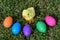 Small Yellow Chick Surrounded By Colorful Easter Eggs On The Green Grass