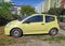 Small yellow Citroen private compact car sedan parked left side view