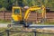 Small yellow crawler excavator for screwing piles