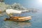 Small yellow motorized boat anchored on the shore in front of rocks