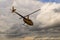 A small yellow private helicopter flies in the direction of thunderclouds. A small private airfield in Zhytomyr, Ukraine