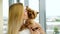 Small Yorkshire terrier on hands of young blonde woman kissing her lovely pet