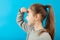 Small young beautiful girl search and looking far away with hand over head. Portrait on blue background