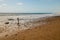 Small young girl stands on a rock on a secluded rocky beach by the ocean