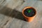 A small young green plant growing in a flower pot on a wooden background - aloe