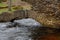 A smaller arch over a flooded creek