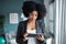 Smart afro young entrepreneur woman using her digital tablet while standing in the office at home