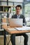 A smart Asian businessman focuses on his work on his laptop at a table in the office