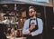 Smart barista in glasses has a break at his own coffeeshop.