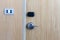 Smart card door key lock system in hotel. Hotel electronic lock on wooden door. Entrance door with electronic card lock security.