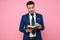 Smart casual man reading book on pink background