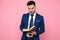 Smart casual man reading on pink background in studio