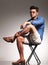 Smart casual young man sitting on a stool