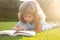 Smart clever Kids. Outdoor portrait of a cute young little boy reading a book. Back to school. Kids education. Beginning