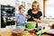 Smart cute child helping mother in kitchen