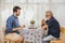 Smart elder playing chess board game at home care with younger man for stay brain healthy