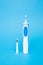 Smart electric toothbrush on a blue isolated background.