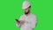 Smart engineer in white shirt and safety engineering hat using smartphone on a Green Screen, Chroma Key.