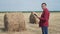 Smart farming agriculture concept. man farmer worker studying a haystack in a field on digital tablet. slow motion video