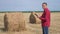 Smart farming agriculture concept. Man farmer worker studying a haystack in lifestyle a field on digital tablet. Slow