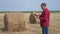 Smart farming agriculture concept. man worker lifestyle farmer studying a haystack in a field on digital tablet. slow