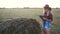 Smart farming slow motion video concept. girl agronomist holds tablet touch pad computer in hay field stack is studying