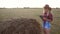 Smart farming slow motion video concept. girl agronomist holds tablet touch pad computer in hay field stack is studying