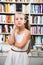 Smart girl child bemused a lot of books in a bookstore