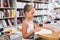 Smart girl child is engaged with a book in the library