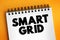 Smart grid - electrical grid which includes a variety of operation and energy measures, text quote concept on notepad