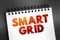 Smart grid - electrical grid which includes a variety of operation and energy measures, text quote concept on notepad