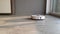 Smart House. Vacuum cleaner robot runs on wood floor in a living room