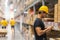 Smart Indian engineer man worker wearing safety helmet doing stocktaking of product management in cardboard box