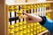 Smart kid counting on soroban abacus. Education, school arithmetic, calculating thinking