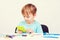 Smart little boy holding calculator. Child doing homework. Back to school concept. School supplies on a white desck