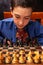 Smart little boy playing chess, a teen grandmaster with vintage chess board