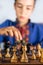 Smart little boy playing chess, a teen grandmaster with vintage chess board