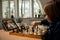 Smart little Caucasian boy chess player playing chess online using laptop.