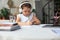 Smart little girl in headphones do homework online class on smartphone, small child in earphones study on Internet