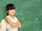 Smart little girl successful standing in front of a blackboard.