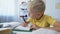 Smart male child doing homework, writing in notebook, education and knowledge