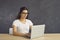 Smart millennial girl in glasses work online on computer