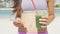 Smart phone woman drinking vegetable Green detox smoothie