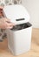 Smart recycle bin. Electronic gadget for home and office. A man`s hand opens a compartment for replacing the trash bag. Stands on