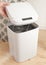 Smart recycle bin. Electronic gadget for home and office. A man`s hand opens a compartment for replacing the trash bag. Stands on