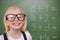 Smart schoolgirl posing in front of a blackboard